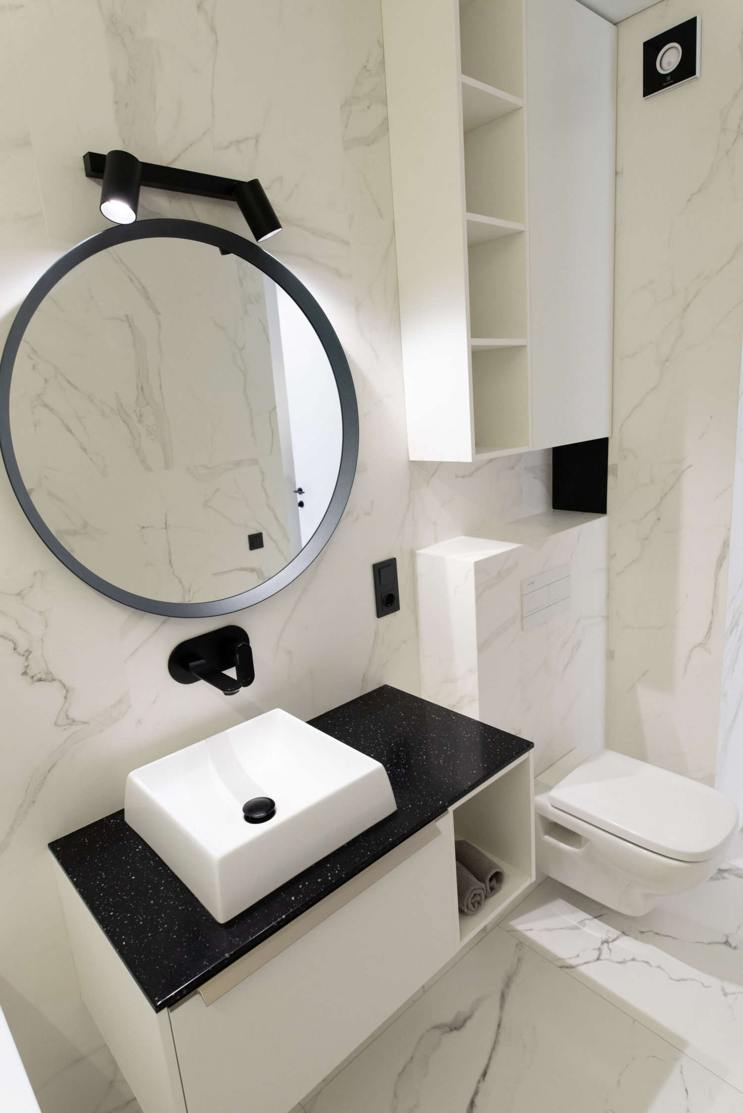 bathroom with marble tiles with a white cabinet and shelves